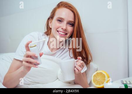 Rothaarige Ingwer Frau an Decke gewickelt und Gefühl schlechte Laune, weil sie Infektion Grippe ist. Epidemie covid-19 Ausbruch Selbstisolierung Stockfoto