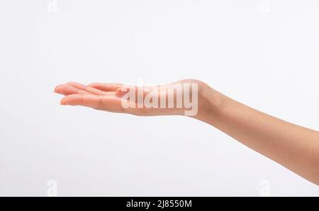 Weibliche Hand mit Handfläche nach oben auf weißem Hintergrund. Geste, leere Hand. Stockfoto