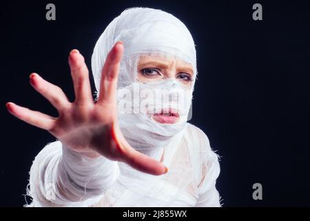 Glamouröse Mama Frau in Verbänden auf ihrem ganzen Körper Studio schwarzen Hintergrund Stockfoto