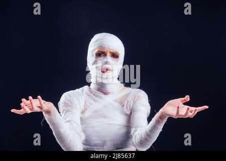 Glamouröse Mama Frau in Verbänden am ganzen Körper in Studio schwarzen Hintergrund. Halloween-Party oder plastische Chirurgie Opfer Konzept Stockfoto