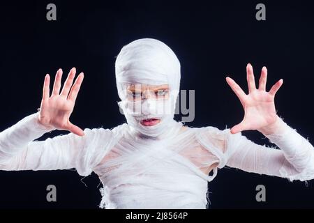 Glamouröse Mama Frau in Verbänden auf ihrem ganzen Körper Studio schwarzen Hintergrund Stockfoto