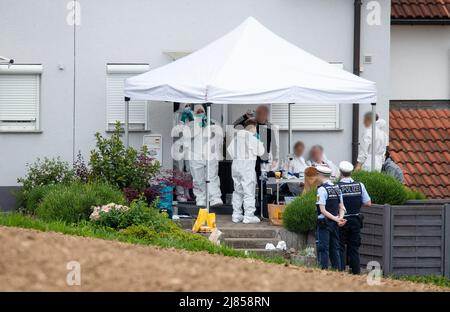 Eberdingen, Deutschland. 13.. Mai 2022. Gerichtsmediziner und Polizeibeamte stehen vor einem Haus, in dem ein Mann vermutlich seine Frau, seine Tochter und sich selbst getötet hat. Quelle: Christoph Schmidt/dpa - ACHTUNG: Person(en) wurden aus rechtlichen Gründen pixeliert/dpa/Alamy Live News Stockfoto