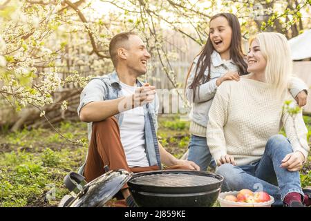 Glückliche Familie mit Grill mit modernen Grill im Freien Stockfoto