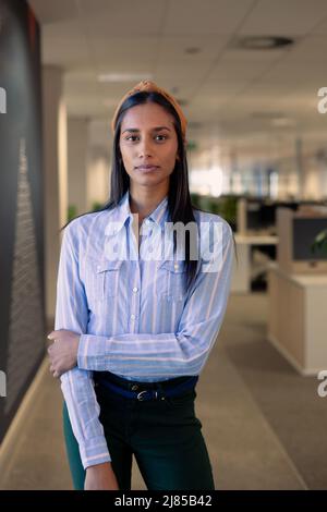 Porträt einer selbstbewussten jungen afroamerikanischen schönen Geschäftsfrau, die am Arbeitsplatz steht Stockfoto