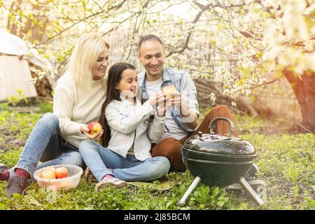 Glückliche Familie mit Grill mit modernen Grill im Freien Stockfoto