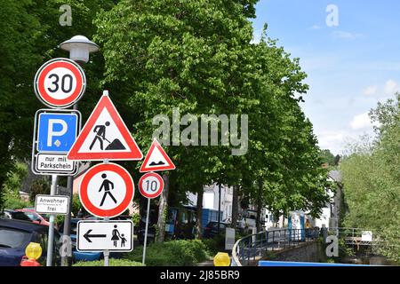 Geschwindigkeitsbegrenzung 10 bei Straßenarbeiten und schlechter Straße plus viele andere Schilder Stockfoto