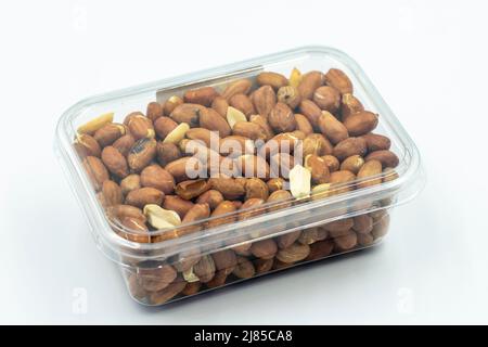 Gepackte Erdnüsse auf weißem Hintergrund. Gesunde Nüsse. Nahaufnahme. Stockfoto