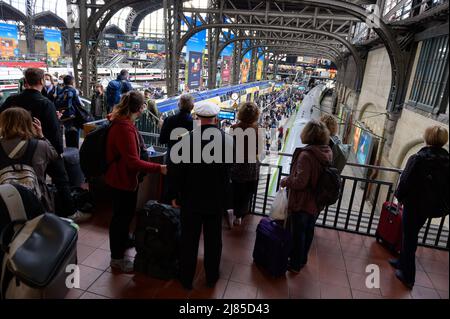 Hamburg, Deutschland. 13.. Mai 2022. Zahlreiche Reisende stehen vor und auf einer Plattform am Hamburger Hauptbahnhof. Aufgrund eines Kabelbrands in Hamburg ist der Fernverkehr stark gestört. Quelle: Jonas Walzberg/dpa/Alamy Live News Stockfoto