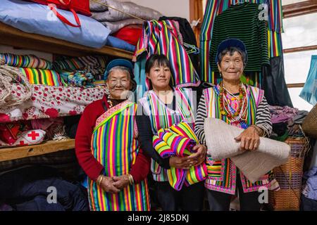 (220513) -- GONGSHAN, 13. Mai 2022 (Xinhua) -- die Dulong-Anwohnerin Li Wenshi (L) und ihre Familienmitglieder zeigen die Dulong-Decken im Dorf Dizhengdang der Gemeinde Dulongjiang, dem Autonomen Kreis Gongshan Dulong und Nu, südwestlich der Provinz Yunnan, 10. Mai 2022. Dulong ist eine in den Bergen lebende ethnische Gruppe im Südwesten Chinas. Es ist eine der am wenigsten bevölkerten Nationalitäten der chinesischen Minderheit. 2018 schüttelte die ethnische Gruppe Dulong die Armut als Ganzes ab, ein phänomenaler Durchbruch. Li Wenshi, der die Dulong-Weben von ihrer Mutter erbte, hat ihre Expertise genutzt, um verschiedene Produkte zu entwickeln Stockfoto