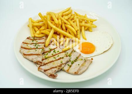 Kombinierter Teller mit Schweinelende mit Kartoffeln und Spiegelei Stockfoto