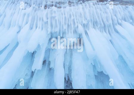 Blaues Eis und Eiszapfen auf den Felsen der Insel Ogoy, Baikalsee, Sibirien, Russland. Abstrakt Winter Natur Hintergrund. Stockfoto