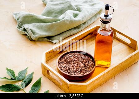 Flasche Sesam-Speiseöl mit Samen in der Schüssel Stockfoto