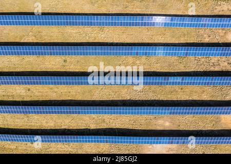 Solarfarm Luftaufnahme, Reihen von PV-Modulen bei einem kleinen Haus Stockfoto
