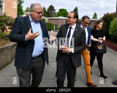 Essen, Deutschland. 13.. Mai 2022. Oberbürgermeister Thomas Kufen (2. v.l., CDU), spricht mit dem Direktor des Klosters Pater Otto Nosbisch (l.) am Don Bosco Gymnasium, um sich einen Eindruck zu verschaffen. Die Polizei hat gestern einen Versuch im Leben der Schule vereitelt. Der 16-jährige Student soll heute vor den Richter gebracht werden. Ebenfalls anwesend sind der stellvertretende Schulleiter Muchtar Al Ghusain (2. v.l.) und die stellvertretende Schulabgeordnete Katrin Höffken (r.). Quelle: Roberto Pfeil/dpa/Alamy Live News Stockfoto