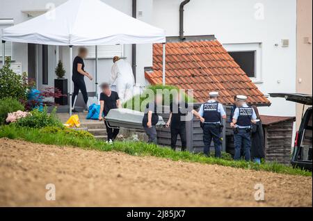 Eberdingen, Deutschland. 13.. Mai 2022. Männer transportieren einen Körper zu einem Leichenwagen. In einem Haus vermutet ein Mann, seine Frau, Tochter und sich selbst getötet zu haben. Quelle: Christoph Schmidt/dpa - ACHTUNG: Person(en) wurden aus rechtlichen Gründen pixeliert/dpa/Alamy Live News Stockfoto