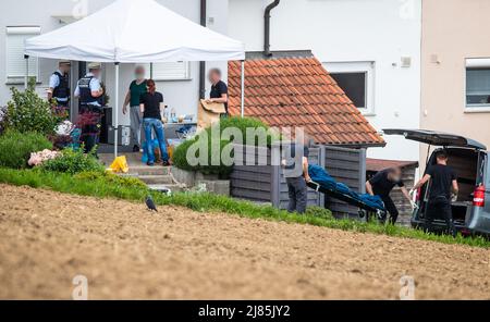 Eberdingen, Deutschland. 13.. Mai 2022. Männer transportieren einen Körper zu einem Leichenwagen. In einem Haus vermutet ein Mann, seine Frau, Tochter und sich selbst getötet zu haben. Quelle: Christoph Schmidt/dpa - ACHTUNG: Person(en) wurden aus rechtlichen Gründen pixeliert/dpa/Alamy Live News Stockfoto