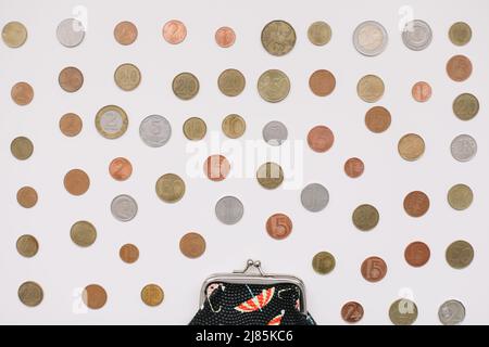 Offene Brieftasche mit verschiedenen Münzen isoliert auf weißem Hintergrund, Draufsicht. Finanzkrise, Armut, Geldmangel Stockfoto