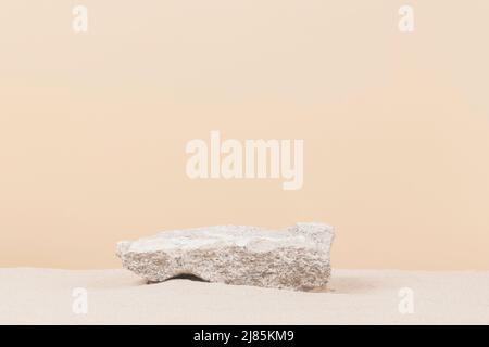 Grungy grauen Betonstein Plattform Podium für Kosmetika oder Produkte auf weißem Sand Hintergrund. Vorderansicht Stockfoto