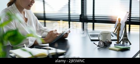 Nahaufnahme Geschäftsfrau Hand hält Stift und digitales Tablet für die Planung der Arbeitszeit im Büro Stockfoto