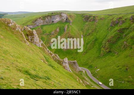 Derbyshire, Großbritannien – 5. April 2018: Autos fahren auf einer kurvenreichen Straße durch den Winnats Pass im Peak District National Park Stockfoto