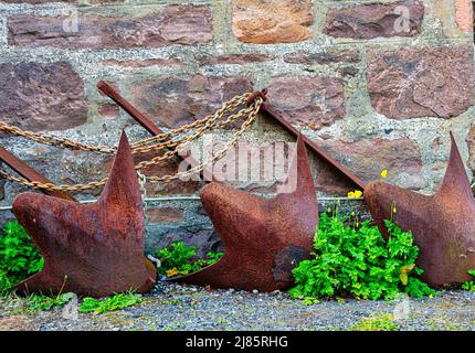 Drei rostige Metallanker und Ketten aus dem Hochlanddorf Plockton, Schottland Stockfoto