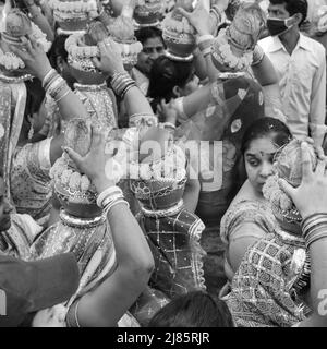 Delhi, Indien April 03 2022 - Frauen mit Kalash am Kopf während des Jagannath-Tempels Mangal Kalash Yatra tragen indische Hindu-Anhänger irdische Töpfe im Container Stockfoto