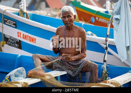 Porträt eines alten Fischers, der sein Fischernetz flicken lässt, Tangassery, Kerala, Indien. Stockfoto