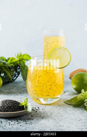 Basilikumsamen trinken mit Orange im Glas auf hellem Hintergrund. Nahaufnahme. Gesundes Detox-Getränk, um Gewicht zu verlieren. Vertikales Format. Stockfoto