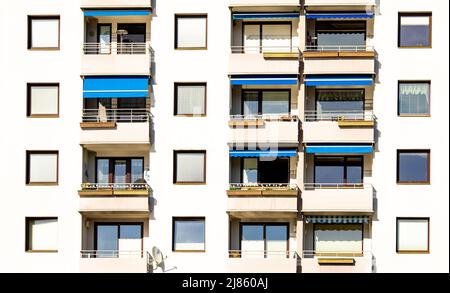 Traditionelle Gebäudefassade mit Fenstern, Jalousie, Balkonen in Österreich, Immobilienkonzept Stockfoto