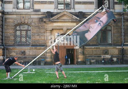 Dresden, Deutschland. 13.. Mai 2022. Techniker haben ein Banner für die Ausstellung „Weltflucht und Moderne“ aufgesetzt. Oskar Zwintscher in Kunst um 1900' vor dem Albertinum in Dresden. Die Staatlichen Kunstsammlungen Dresden zeigen die Ausstellung vom 14. Mai 2022 bis zum 15. Januar 2023 mit insgesamt 88 Gemälden, 10 Skulpturen, 25 Zeichnungen und 2 Aquarellen von Zwintscher und anderen Künstlern seiner Zeit. Quelle: Matthias Rietschel/dpa/ZB/dpa/Alamy Live News Stockfoto