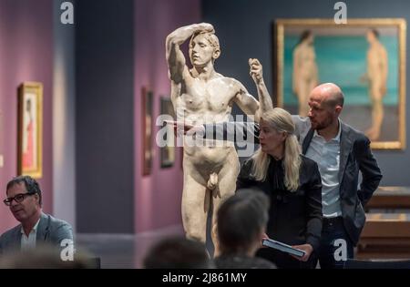 Dresden, Deutschland. 13.. Mai 2022. Besucher und Medien stehen neben August Rodins 'The Brazen Age, 1877' während der Vorschau der Ausstellung 'Weltflucht und Moderne. Oskar Zwintscher in Kunst um 1900' im Albertinum in Dresden. Die Staatlichen Kunstsammlungen Dresden zeigen die Ausstellung vom 14. Mai 2022 bis zum 15. Januar 2023 mit insgesamt 88 Gemälden, 10 Skulpturen, 25 Zeichnungen und 2 Aquarellen von Zwintscher und anderen Künstlern seiner Zeit. Quelle: Matthias Rietschel/dpa/ZB/dpa/Alamy Live News Stockfoto