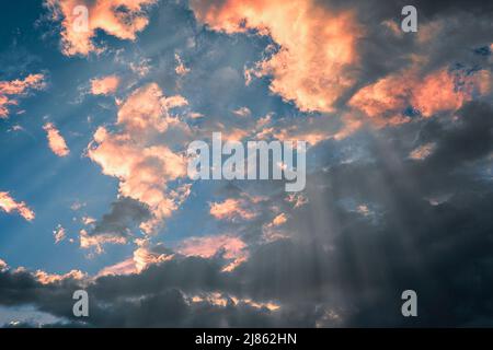 Göttliches Leuchten durch die Wolken der Abendsonne. Konzept von Frieden und Glück. Stockfoto