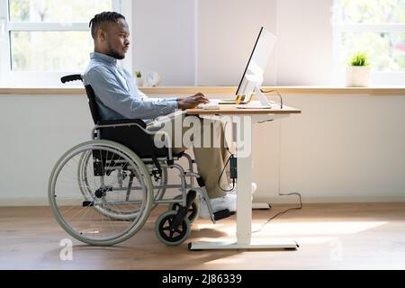 Afroamerikanischer Schwarzer Mann Mit Computer. Mitarbeiter Mit Behinderung Stockfoto