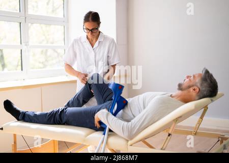 Physiotherapeut Überprüft Das Knie Des Patienten. Physiotherapie Und Schmerzen Stockfoto