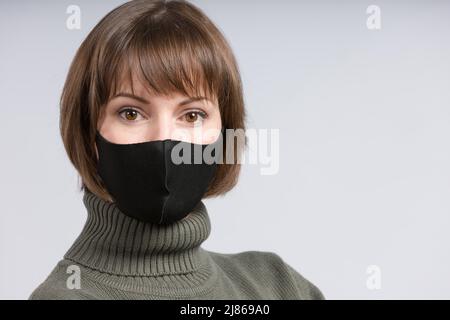 Porträt einer jungen Frau mit schwarzer Stoffmaske Stockfoto