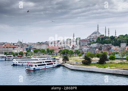 Istanbul, Türkei. 5.. Mai 2019. Die Fähren liegen entlang der Westküste mit der Moschee Einer Mutter und ihrem Sohn, die auf den Docks von SÃ¼leymaniye im Hintergrund auf die Fähre warten. Der Seeverkehr mit Fähren ist eine Besonderheit Istanbuls. Trotz des tiefsten Tunnels der Welt unter dem Bosporus für die U-Bahn und der Einweihung der neuen „Canakkale 1915-Brücke“ im März 2022 fördern die Bevölkerung und der 2019 neu gewählte Bürgermeister von Istanbul den Seeverkehr, um den Straßenverkehr zu entlasten und die Emissionen von CO2 zu reduzieren. (Bild: © Laurent Coust/SOPA Images via ZUMA Press Wire) Stockfoto