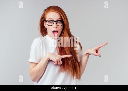 Rothaarige Ingwer-Frau, die sich glücklich fühlt, trägt weißes Baumwoll-T-Shirt im grauen Studio-Hintergrund Stockfoto