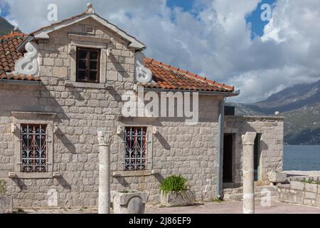 Altes, helles Steinhaus auf einer heiligen Insel inmitten eines Sees mit Terrakottaböden und blauem Himmel Stockfoto
