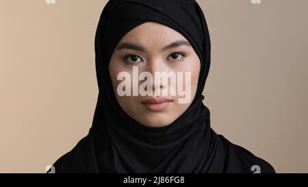Portrait ernste asiatische koreanische malaysische Mädchen in schwarz hijab traditionelle Kopftuch einsame muslimische Frau allein islamische Frau traurig aufgeregt Dame Blick auf Stockfoto