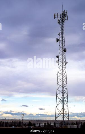 Ein Mobilfunkturm und eine Kommunikationsantenne in einem Naturpark in Airdrie, Alberta, Kanada. Stockfoto