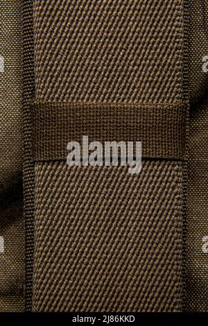 Nahaufnahme Textur eines Rucksack aus Canvas-Stoff. Lederriemen und Metallschnallen. Vintage Khaki Hintergrund. Stockfoto