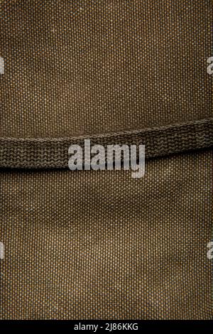 Nahaufnahme Textur eines Rucksack aus Canvas-Stoff. Lederriemen und Metallschnallen. Vintage Khaki Hintergrund. Stockfoto