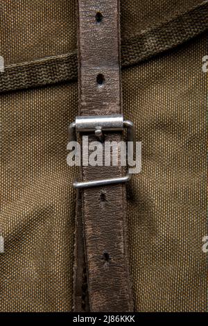 Nahaufnahme Textur eines Rucksack aus Canvas-Stoff. Lederriemen und Metallschnallen. Vintage Khaki Hintergrund. Stockfoto