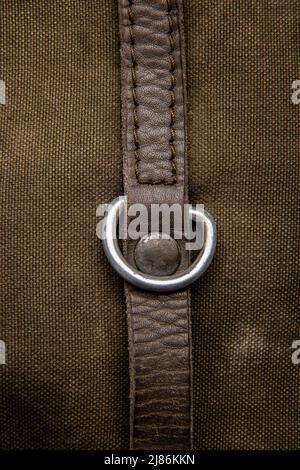 Nahaufnahme Textur eines Rucksack aus Canvas-Stoff. Lederriemen und Metallschnallen. Vintage Khaki Hintergrund. Stockfoto