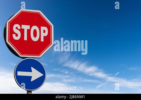 Nahaufnahme einer Einbahnstraße und einem Stoppschild vor einem klaren blauen Himmel mit Wolken und Kopierraum. Italien, Europa. Stockfoto