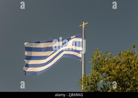 Griechische Nationalflagge mit Kreuzkreuz in Nahaufnahme der Kirche in Paphos, Zypern. Stockfoto