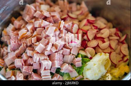 Fein gehackte Lebensmittel zum Kochen Okroshka Nahaufnahme. Okroshka ist eine kalte Suppe ukrainischer Herkunft. Stockfoto