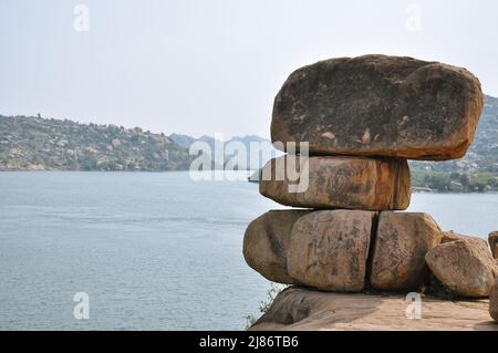 Riesige Steine, die in einer Pyramide am Flussufer in Hampi, Karnataka, Indien, angelegt wurden, Januar 2020 Stockfoto