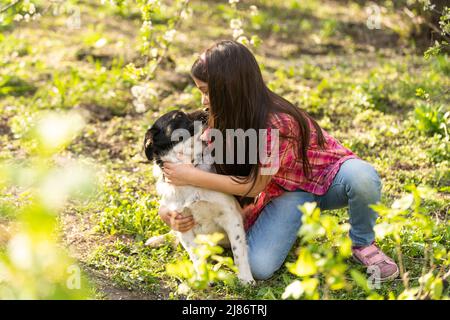 Kleine niedliche Mädchen umarmen und ruht auf Schulter Hund. Stockfoto