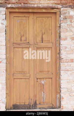 Alte Holztür in Betonwand, Stockfoto